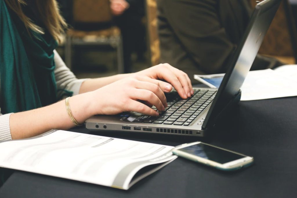 girl typing on laptop while sitting at a desk